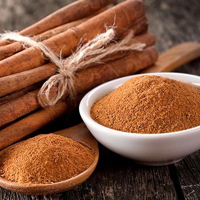 Toz tarçın dolu kaşık ve tarçınlı sütlü tatlı